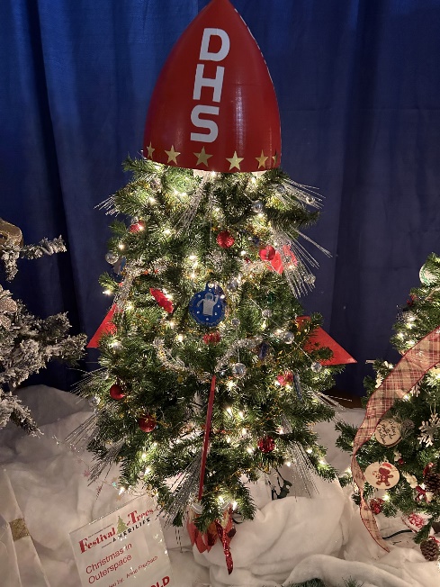 A christmas tree with a red and white object on topDescription automatically generated